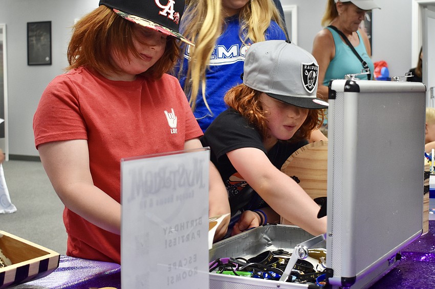 Avi Sigal-Verier, 8 and his brother Joah Sigal-Verier, 6, successfully open a box in an activity by Mysterium Escape Room.