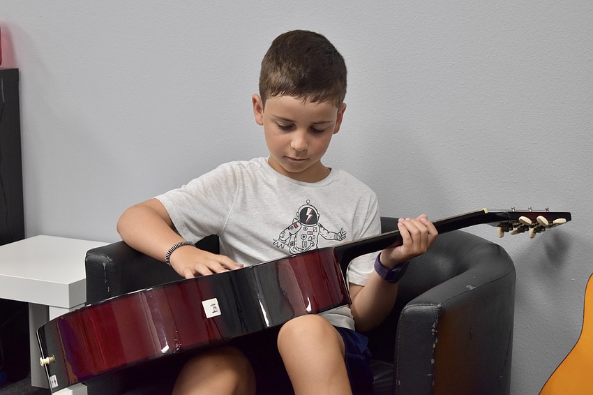 Levi Schwartz, 9, plays the guitar in the music lounge.