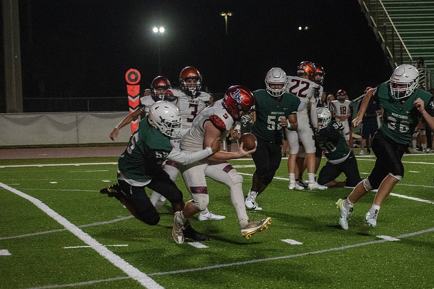 Mustangs junior Caua Magno makes a tackle on Lemon Bay High quarterback Drew Smith.