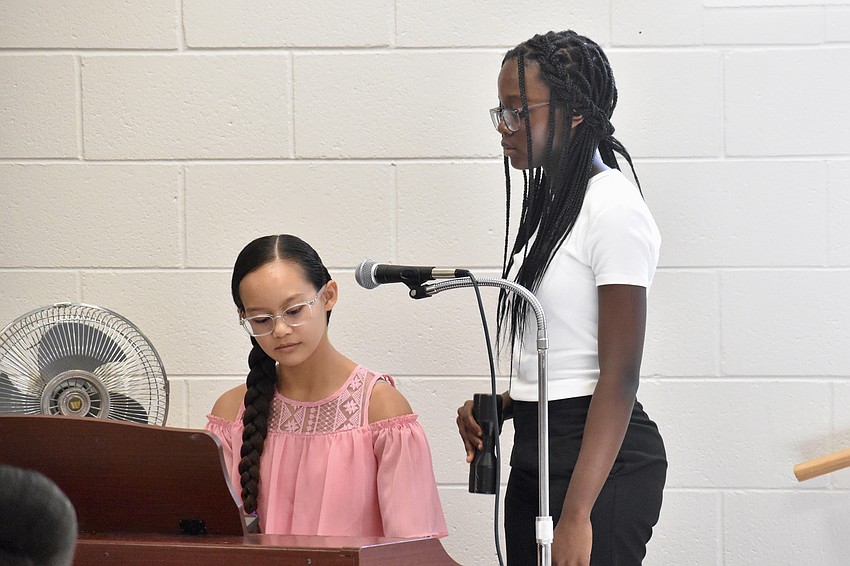 Ziarymar Cerdenio-Santiago, 16 and Samira Addae, 11, offer a musical performance before the graduation.