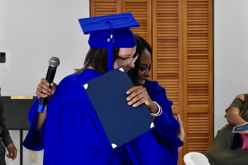 Aime Merda, 13, offers Ronnique Hawkins a hug.