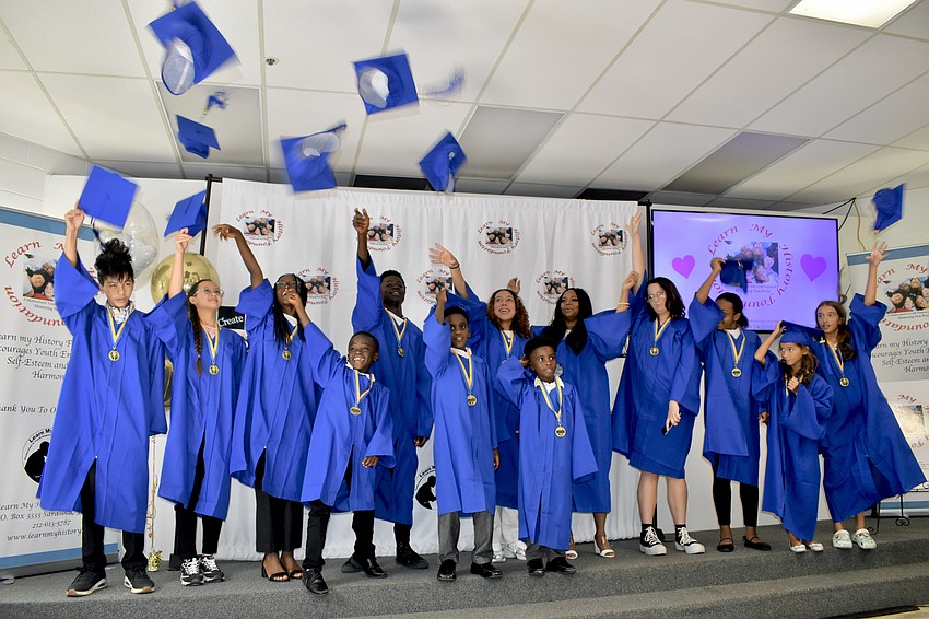 Graduates toss their caps into the air.