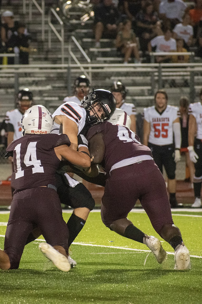 Braden River senior Nicholas Nesser (14) and sophomore Freedom McDaniel put a hit on Sarasota freshman Reed Lengel.