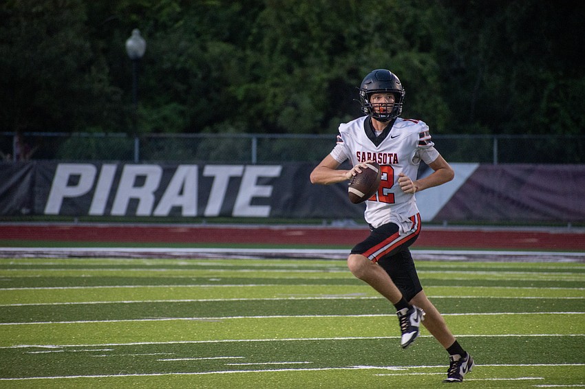 Sarasota freshman quarterback Hudson West rolls to his right, looking for an open receiver.