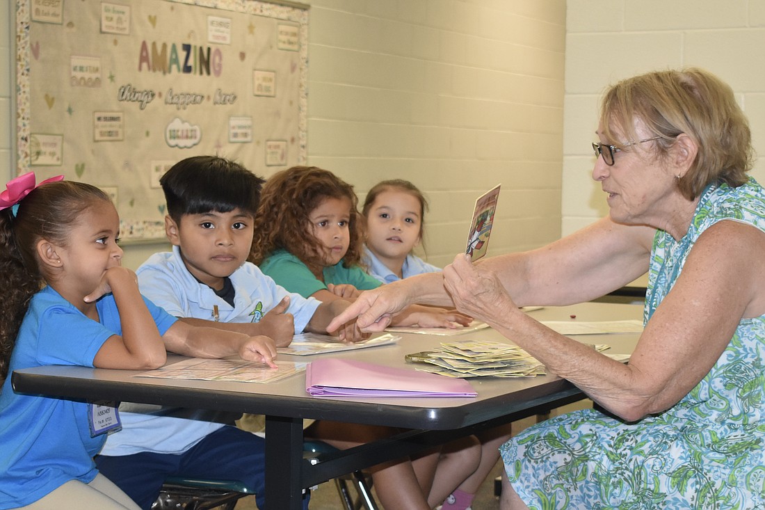 Valeria Torres, Brian Guzman-Orozco, Yesica Mojena and Angelinna Lopez Ferrales practice letter sounds with Deb Petti.