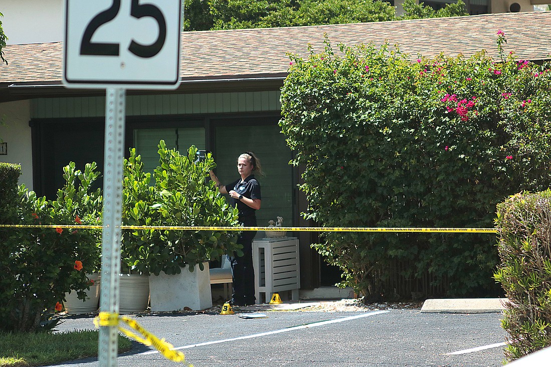 A crime scene technician stands in the doorway of a home in the 700 block of S. Boulevard of the Presidents on Lido Key Sept. 3. Two men were found dead at the home which was being rented, police said.