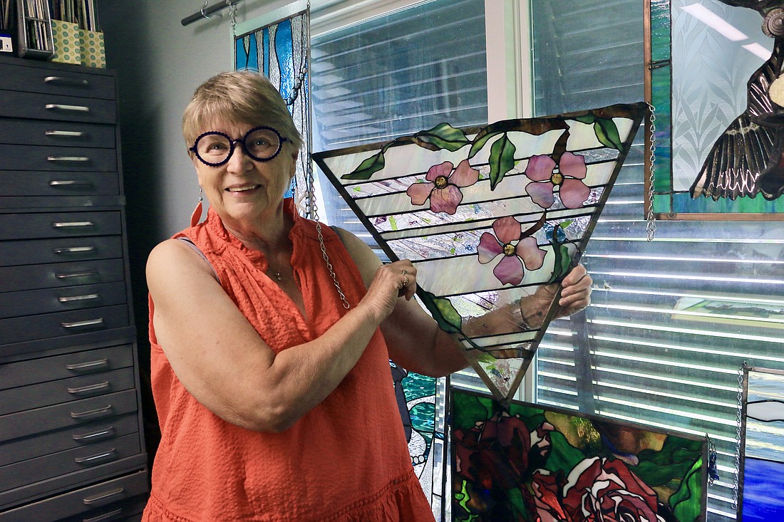 Artist Pat Conway with one of her stained glass pieces. Photo by Sierra Williams