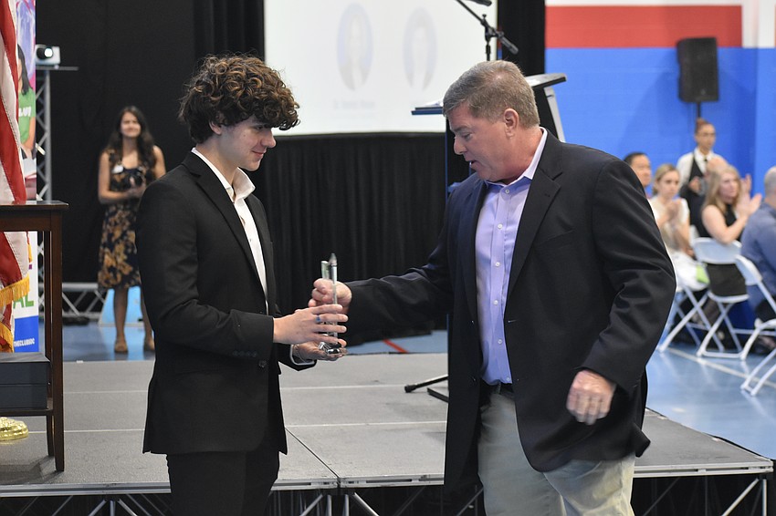 John B., a senior at Pine View School, presents the award to Jack Cox, president and owner of Halfacre Construction.
