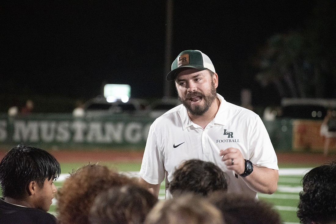 Lakewood Ranch High Head Coach Scott Paravicini talks with his team following a 41-3 win over Braden River High. It was the Mustangs' first win over the Pirates since 2013.