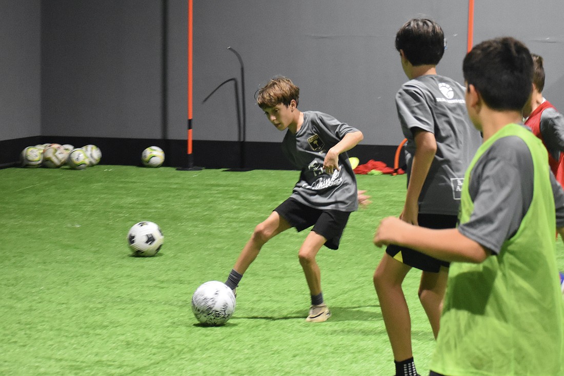 Trey Hamer, 11, works with other youth soccer players at the new indoor facility, The Fitballer.