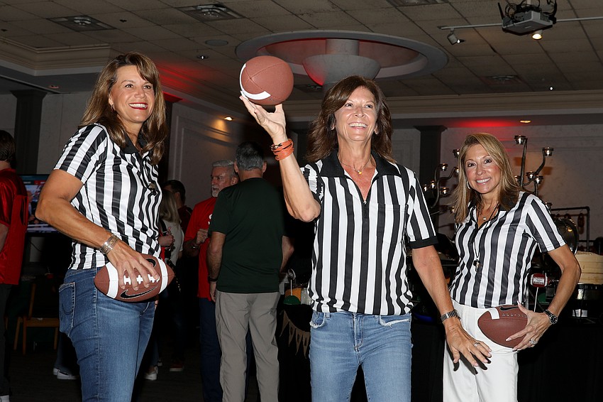 Beth Greene and Jenn Horiuchi stand by as Nancy Lagnese attempts to throw the pigskin through the field goal.
