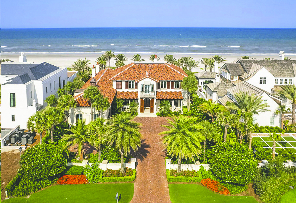 Oceanfront two-story home with golf course views features four bedrooms, four full and two half-bathrooms, bonus room, guest suite, library, elevator, pool, porches, paver driveway and dune walkover.