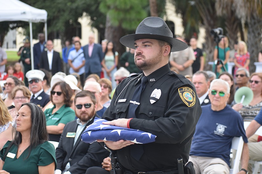 Officer Alex Halley of New College of Florida's Campus Police Department carries the flag.