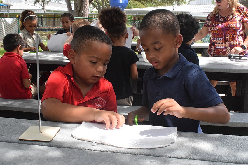 Kindergartners Azavier Williams and Marvin Hendon work together to make their oyster rag pot.