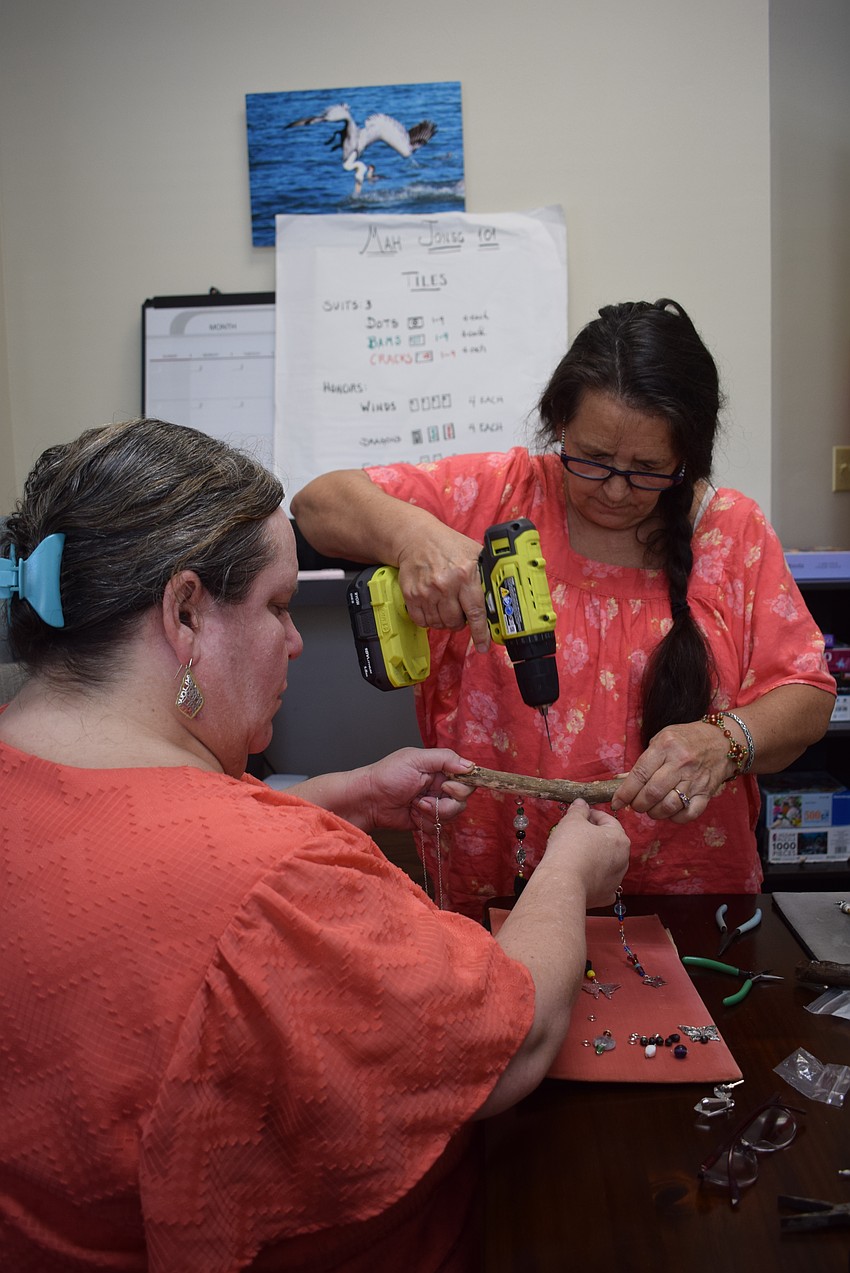 Debbie Lemieux helping Christine Rothberg make a suncatcher at the Paradise Center.