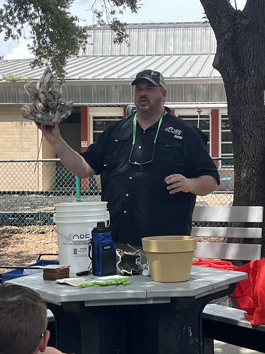 Damon Moore, the executive director of Oyster River Ecology Inc. shows what the students' oyster rag pots will look like after at least a year as it becomes covered in oysters.