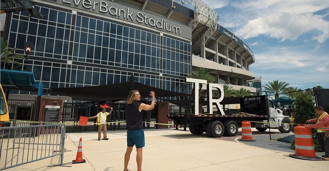 Jacksonville Jaguars quarterback Trevor Lawrence is shown preparing to make modifications to the EverBank Stadium sign in an ad featured on the EverBank.com website.