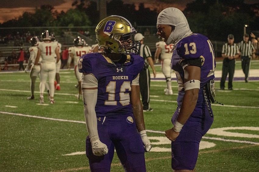 Booker junior Torry Holloman (16) and senior Dajien Walton (13) celebrate after a big Holloman hit against Carrollwood Day.