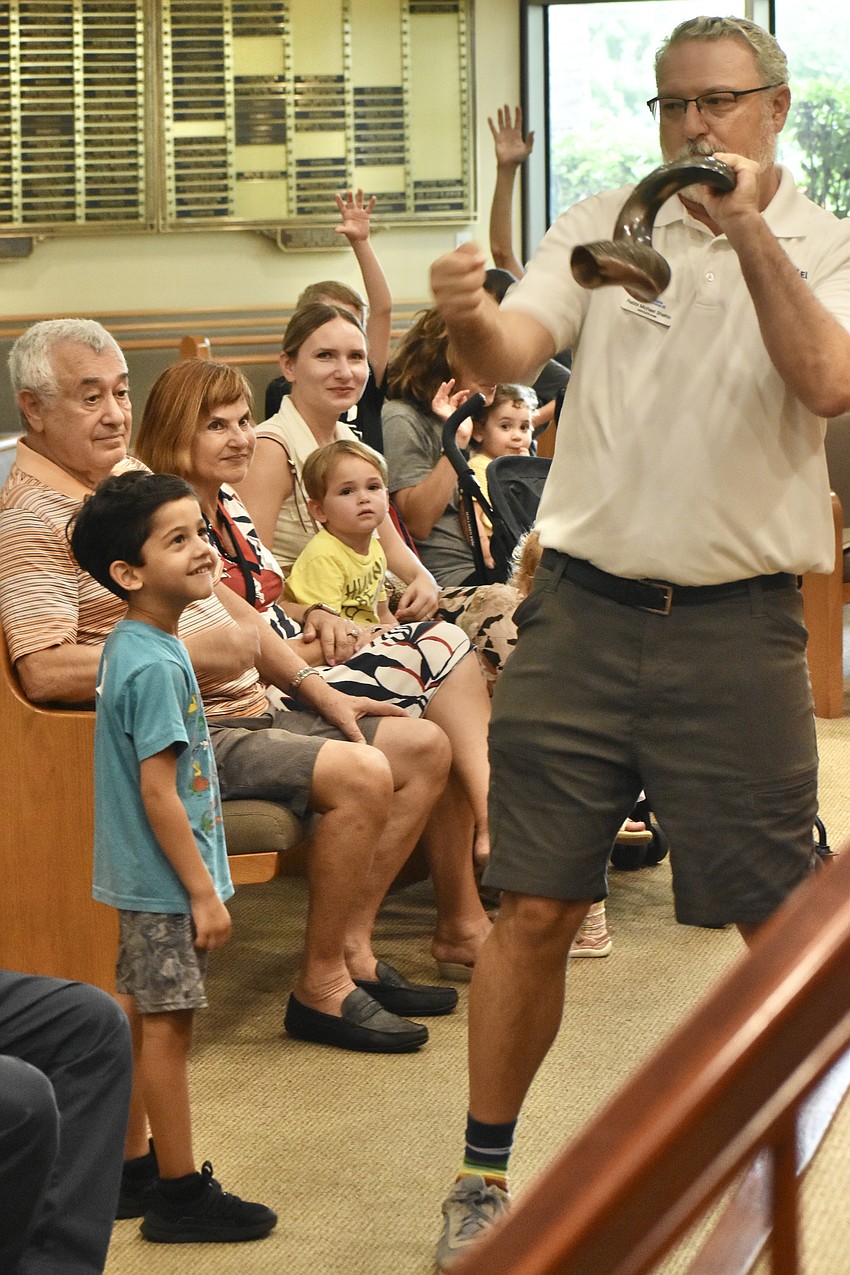 Aitan Weiman, 4, watches as Rabbi Michael Shefrin blows the shofar.