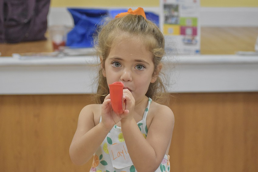 Layla Goldman, 3, blows on a toy shofar.