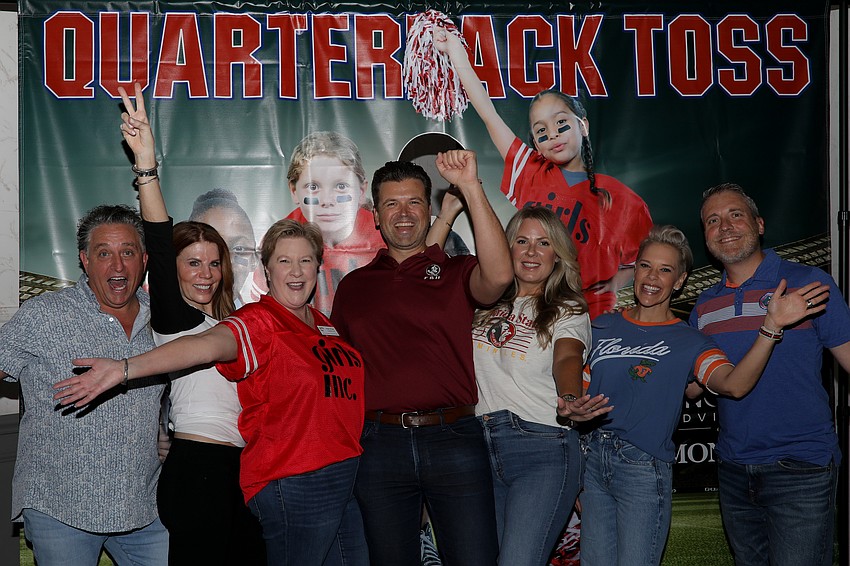 Pick Six co-chairs Glen Reith, Renee Phinney, Danny and Fondren Watts, and Melissa and Scott Perrin give a collective cheer with Girls Inc. President and CEO Angie Stringer (in red).