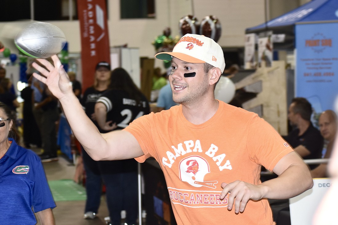 Jordan Sebastiano of Servpro tosses a football.