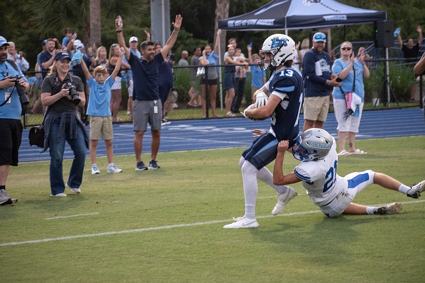 ODA senior Carson Fisher (13) catches a pass from junior running back Allen Clark in the end zone for a touchdown despite a tackle attempt from Sarasota Christian sophomore Wyatt Campbell (21).