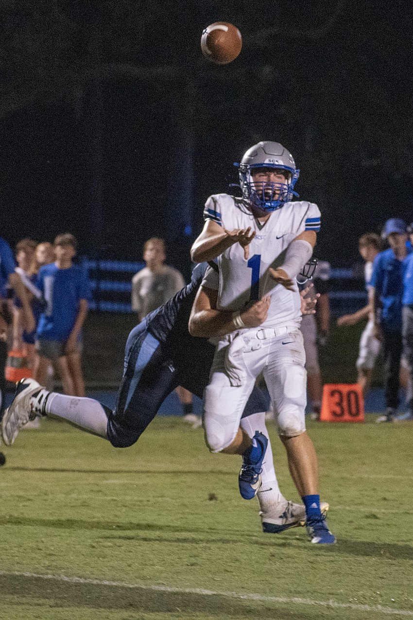 Sarasota Christian junior quarterback Ben Milliken gets off a pass while being hit by ODA senior Chase Mcinerney.