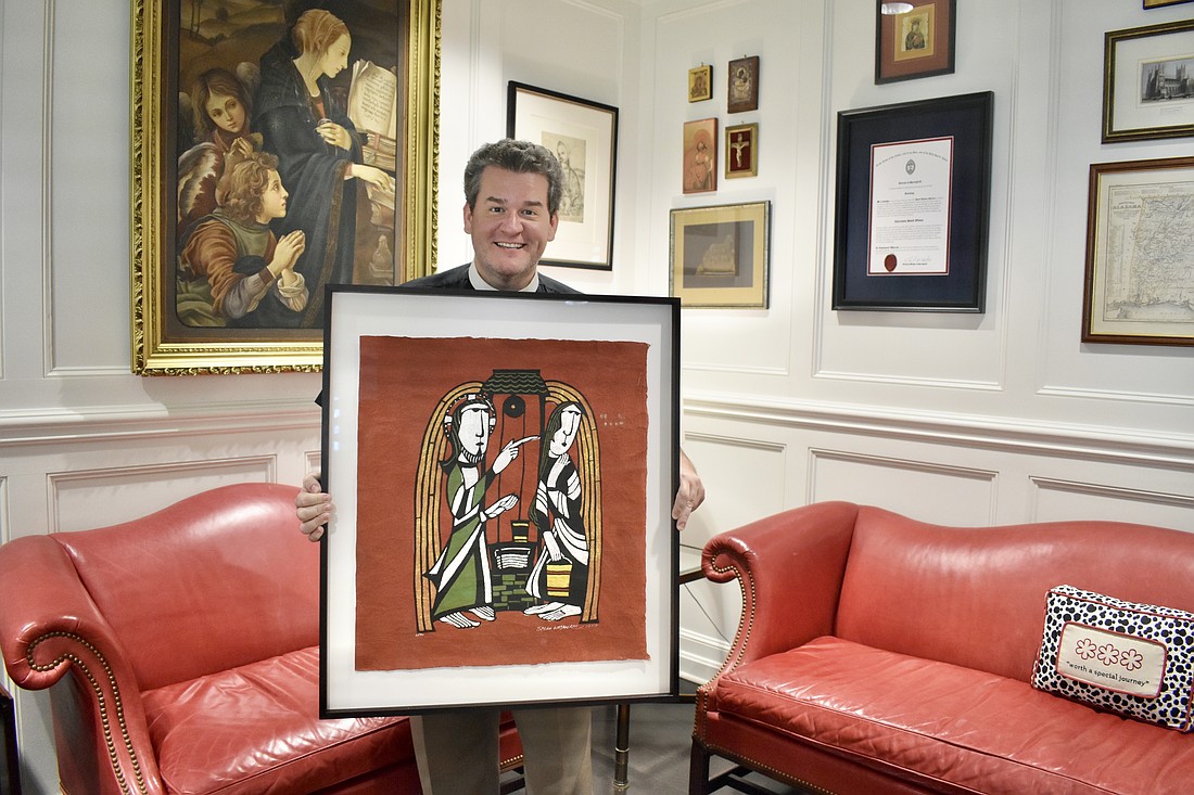 Rev. Charleston Wilson holds a print depicting Jesus and the Samaritan woman at the well.