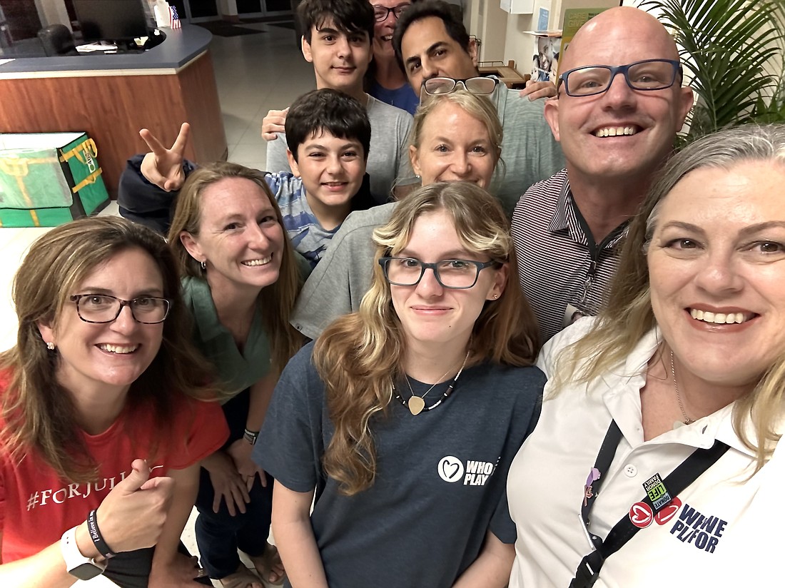 Speakers at the Sept. 18 School Board meeting, including Who We Play For team members and Flagler County families, celebrate the board's approval of an ECG screening mandate for student athletes, marching band members and JROTC cadets. Courtesy photo