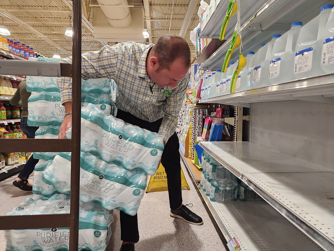 Bay Street Publix employee Peter Wade stocks shelves of drinking water on Tuesday, Sept. 24 ahead of Hurricane Helene. Wade remarked to a customer that he had a couple pallets of water in the back.