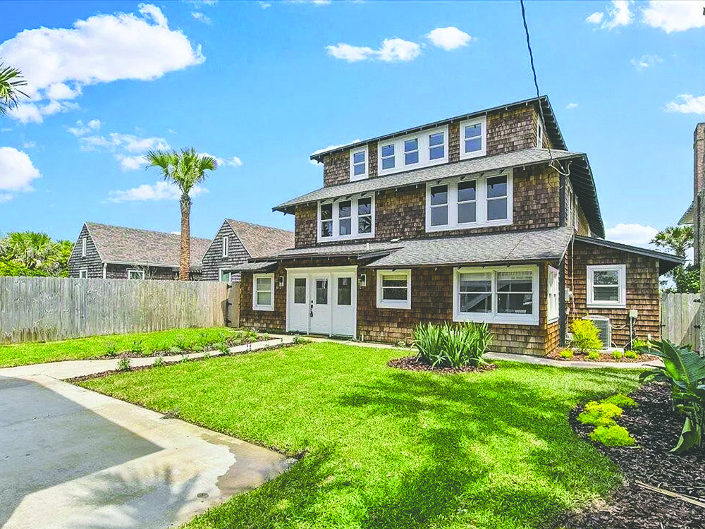 Oceanfront three-story home features four bedrooms, three bathrooms, flex room, deck, porches, balcony and detached garage apartment.