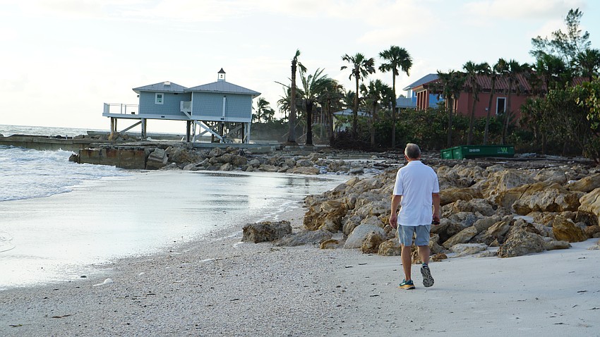 Town Manager Howard Tipton walks the beach along Gulfside Road. In the distance, a house on stilts seems to have survived.