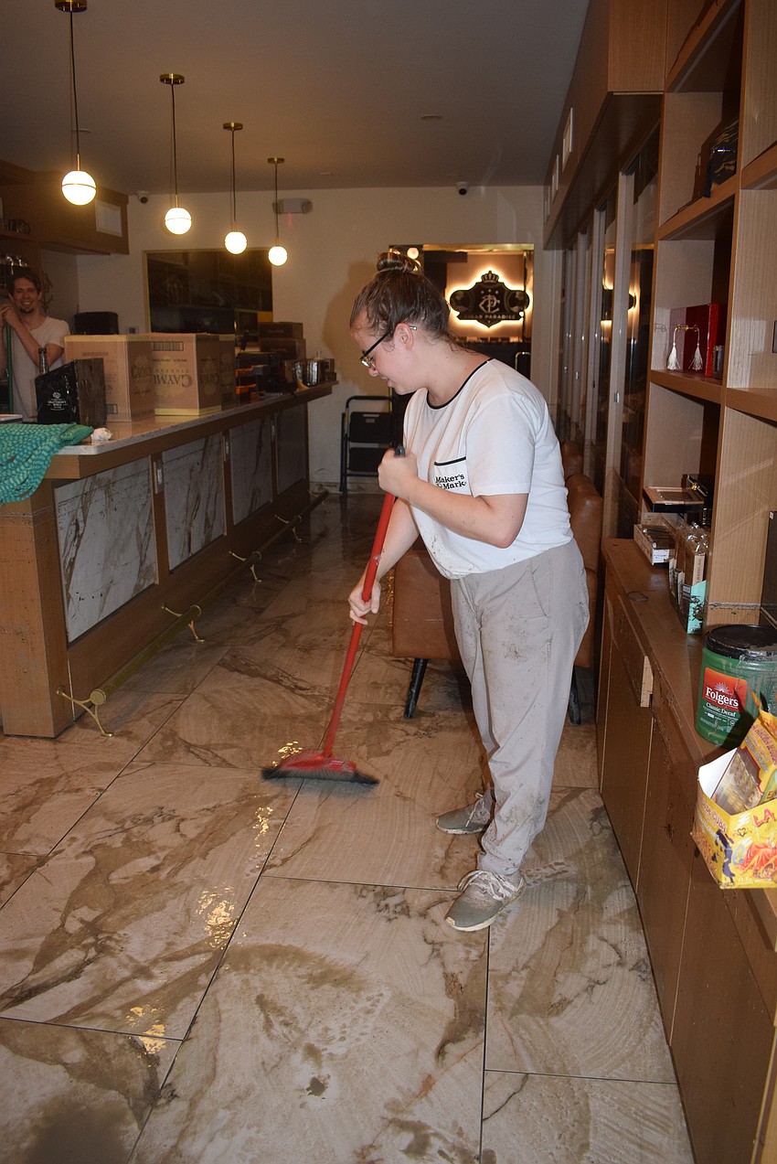 Cigar Paradise Manager Carolyn Conne cleaning up after Hurricane Helene.