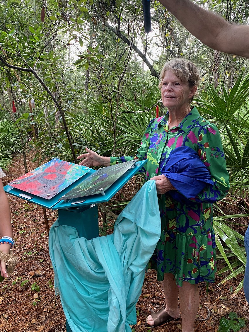 Church member Jamie Reagan unveils two pieces of permanent art along the path.