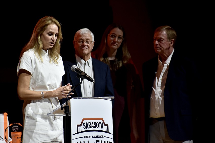 Angela Bartlett speaks in memory of Adrian Garrett, accompanied by Jimmy Garrett, Alexa Bartlett and Wayne Garrett.