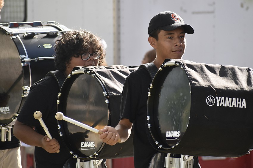 Sarasota High School students, 11th grader Oscar Ramirez and 9th grader Miguel Mercado, help the marching band to serenade guests as they enter.