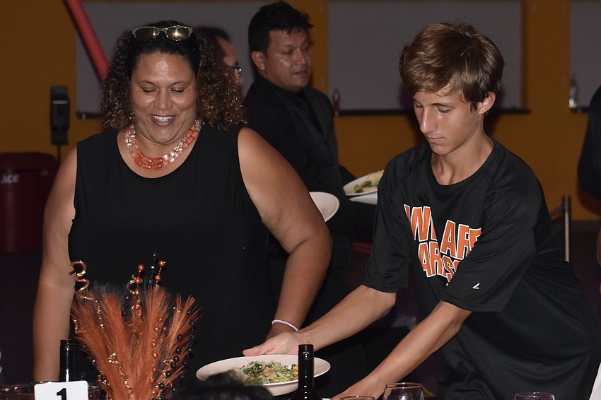 Amy Fulton receives a salad from Sarasota High School student Jack Greenwell