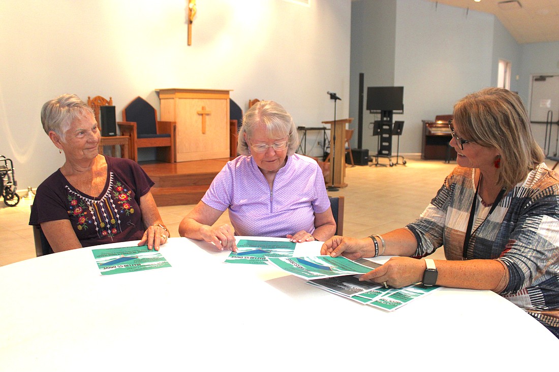 Our Lady of the Angels parishioners Theresa Phillips and Ruth Harenchar talk with Chaplain Mary Peterson about the Bradenton Bridge program.