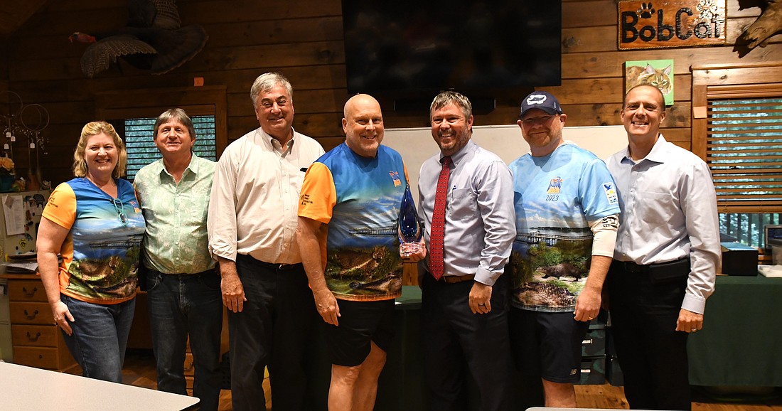 Award recipient Joe Dunn, center, accepted the honor at the Sept. 10 Friends of Lake Apopka board meeting. With him are board members, board executives and former recipients.