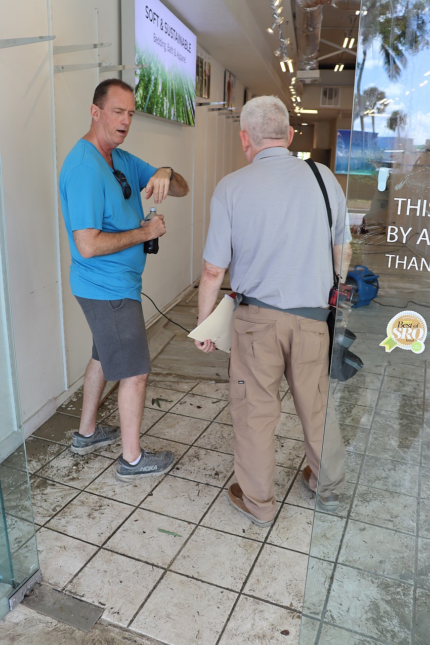 Jeff Sell, owner of Cariloha at St. Armands Circle, speaks with an insurance adjuster about damage to his store.