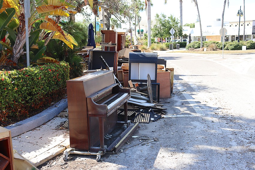 Debris from Crab & Fin, including the piano, is piled up along St. Armands Circle.