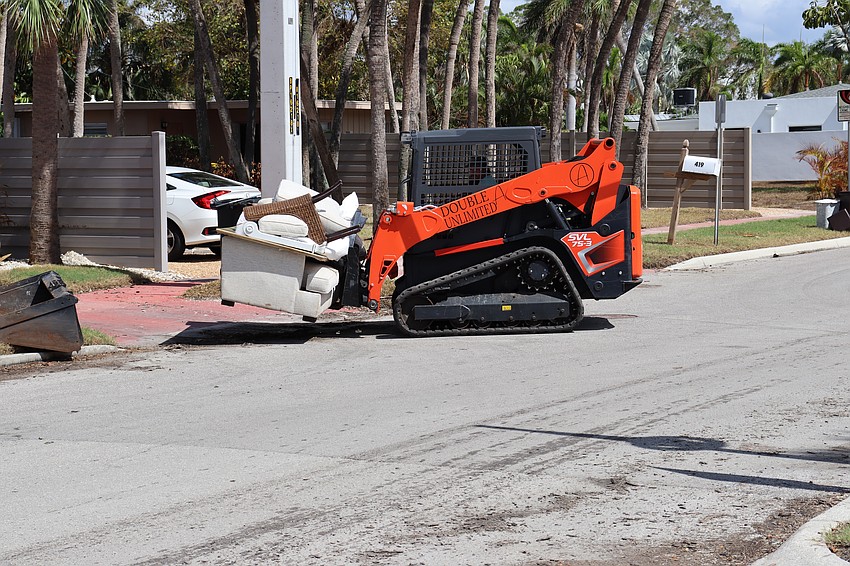A debris hauler removes furniture and other debris from a home just steps away from the St. Armands business district.