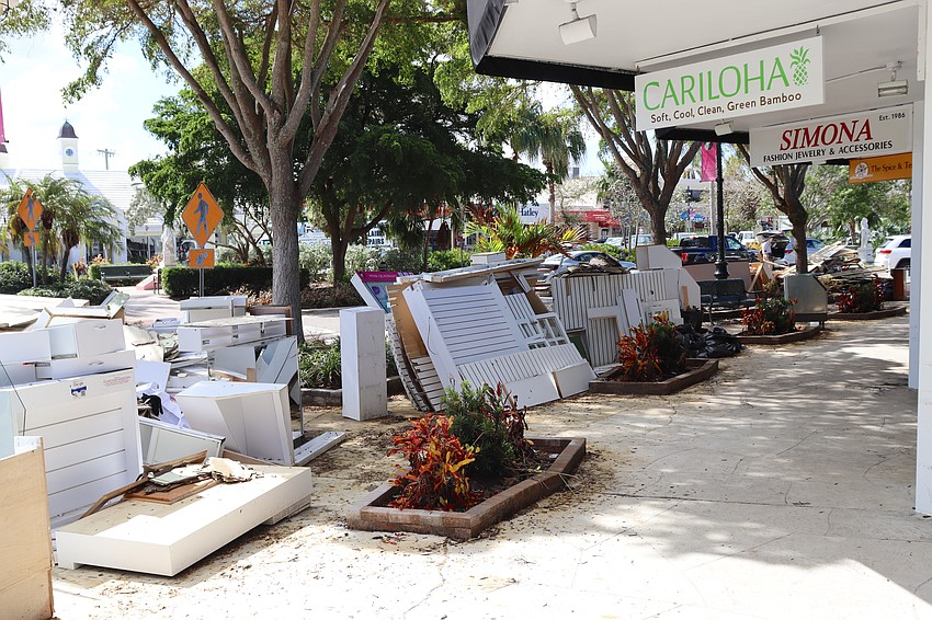 Storm debris outside multiple stores at St. Armands Circle. Most stores have been gutted, some to the studs.