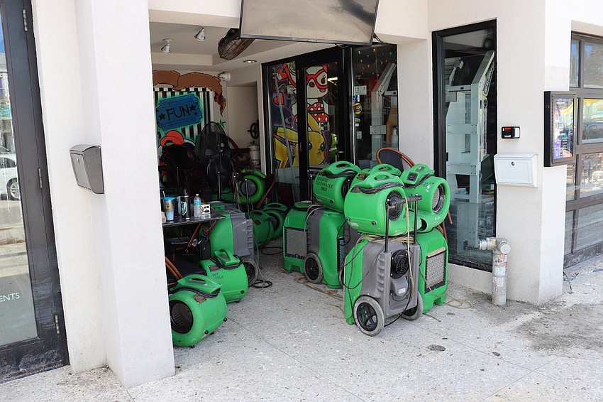 Fans are stacked on St. Armands Circle awaiting deployment to a damp storefront.