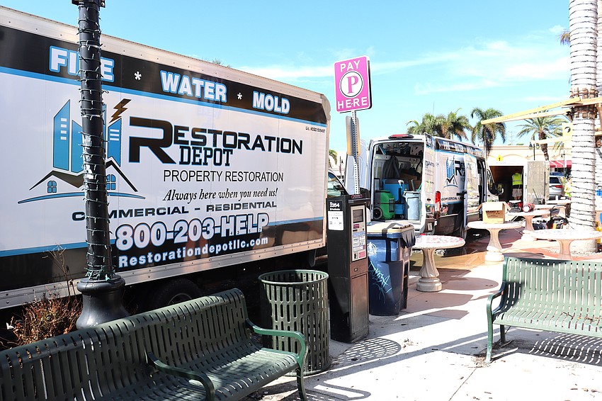 Restoration company trucks are lined up on St. Armands Circle as recovery work is underway.