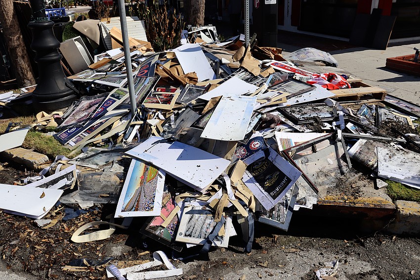 Ruined prints and memorabilia from The Stadium Gallery on St. Armands Circle are piled up on the sidewalk outside.