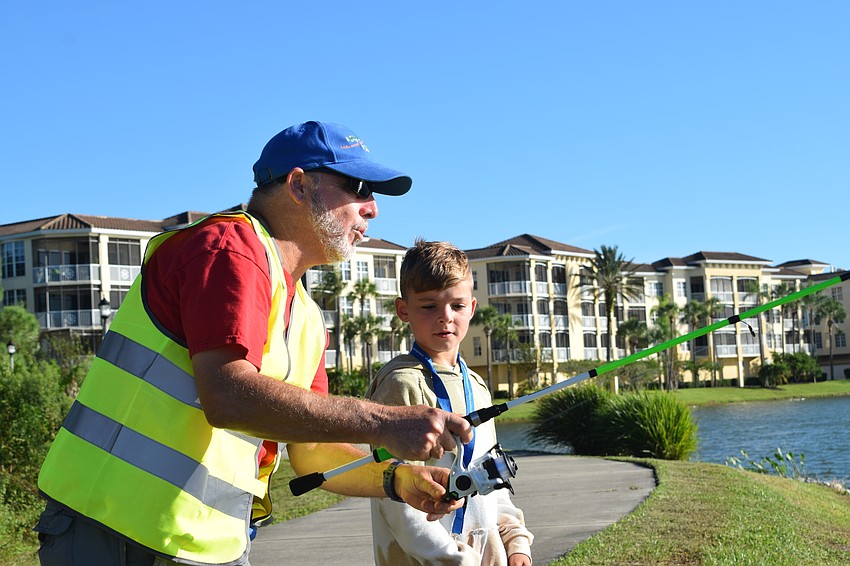 Ed Catalane, a volunteer ranger, helps Lakewood Ranch 8-year-old Avery Green work on his casting technique.