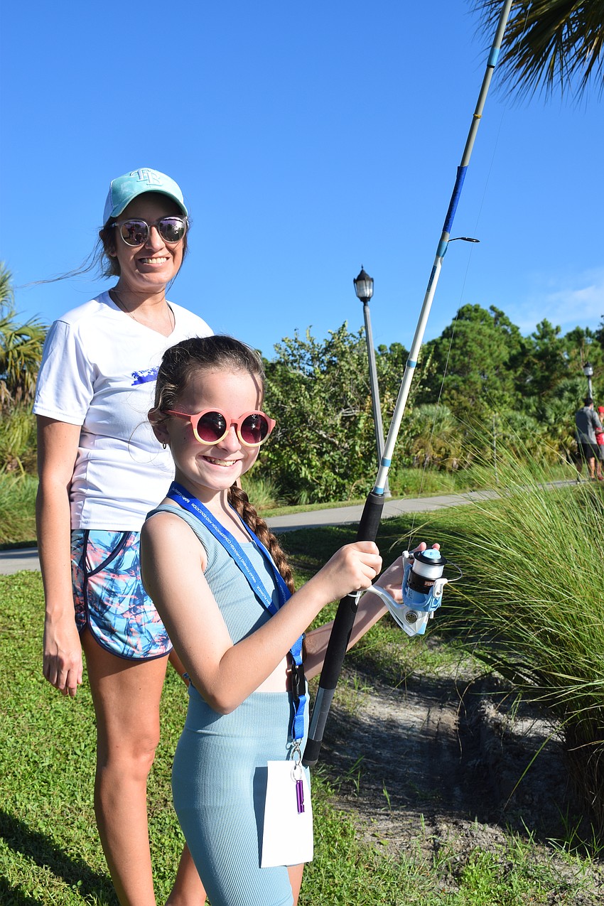 Mill Creek's Lindsey Carr helps her 9-year-old daughter Joslyn Carr cast her line. 