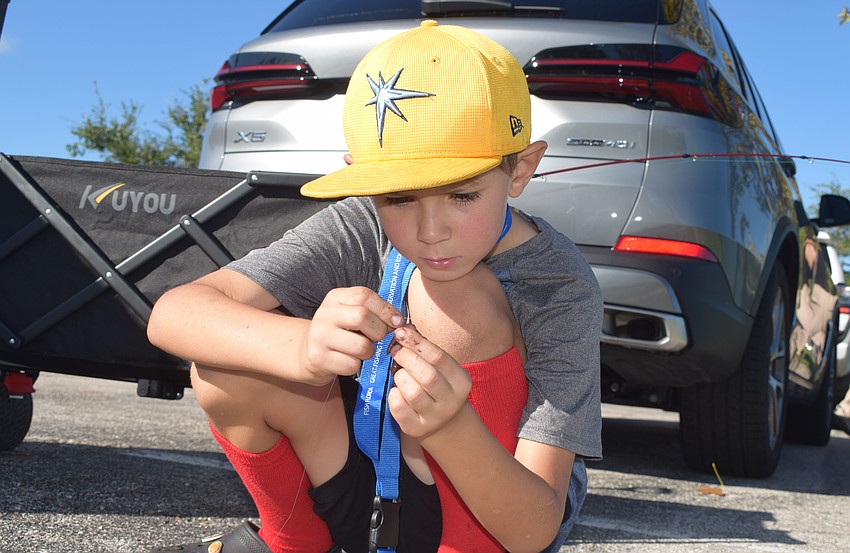 Taylor Miller, an 8-year-old visiting from St. Petersburg, prepares his bait and fishing rod.